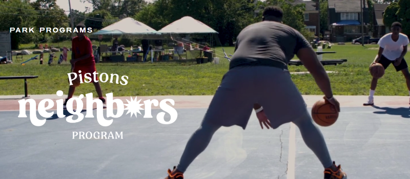 people dribbling basketballs on an outdoor court